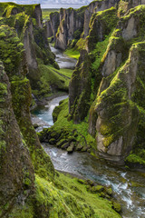 Fjaðrárgljúfur Canyon in southern Iceland. The canyon was carved through the lava and palagonite by progressive erosion by  the Fjaðrá River, fed by meltwater from glaciers over millennia.