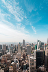 New York City Manhattan, NYC/ USA - 08 21 2017: Top of the Rock panorama view over skyline from Rockefeller center to NYC and the Empire State building on a light cloudy sunny day with blue sky