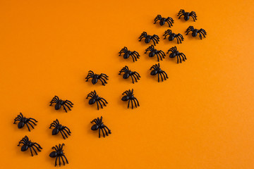 Halloween background. Traditional halloween decor. Spiders on an orange background. Place for text.