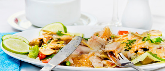 Pieces of Pomfret fish on a fork close-up.