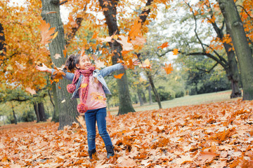 Mädchen im Herbst wirft bunte Ahornblätter in die Luft Natur 