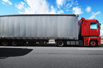 Truck with a trailer on the countryside road against sky