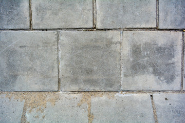 Large square cement street floor slabs. Texture of gray dirty tiles pavement