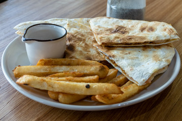 French fries and quesadilla on plate