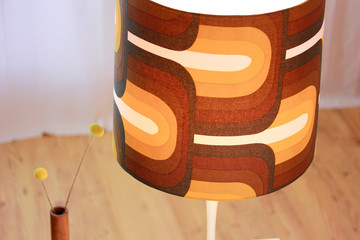 a vintage midcentury lamp from the 60s with a large brown lampshade standing on a cocktail table in...