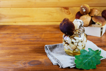 Marinated mushrooms in a jar on a wooden table. Fermented food.