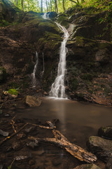 Small pond, waterfall and mossy rocks in the beautiful forest