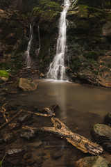 Small pond, waterfall and mossy rocks in the beautiful forest