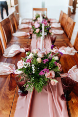 Vintage festive table setting with pink roses, candles and cutlery on an old wooden board