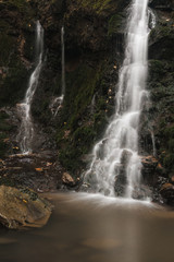 Small pond, waterfall and mossy rocks in the beautiful forest