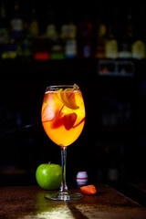 Red cocktail with strawberry slices and Apple