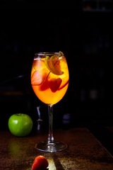 Red cocktail with strawberry slices and Apple