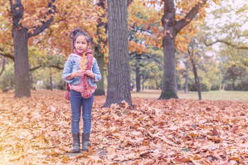 Mädchen mit Blättern und Schal in Naturlandschaft im Herbst