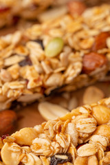 granola bars and nuts on a wooden background with space for design, vertical photo, diet, proper nutrition