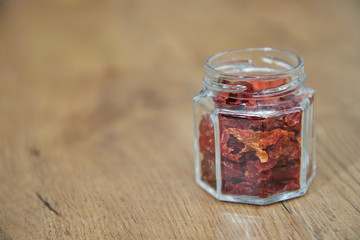 getrocknete chili im einmachglas auf holzbrett
