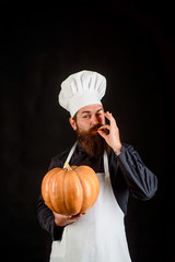 Seasonal vitamin. Autumn recipes concept. Happy halloween. Thanksgiving day cooking. Useful vegetables. Autumn crop. Happy chef man with beard holds pumpkin. Bearded man cook in chef hat with pumpkin.