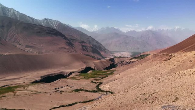 Aerial over arid mountains near Wakhan corridor.Pamir highway silk road trip adventure in Kyrgyzstan and Tajikistan desert region,central Asia.4k drone flight establisher video