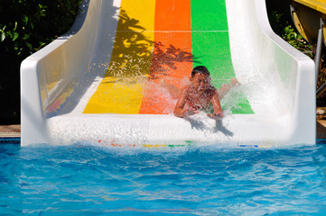 Boy riding a water slide on his stomach