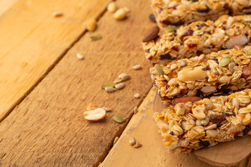 granola bars and nuts on a wooden background with space for design, horizontal photo, diet, proper nutrition