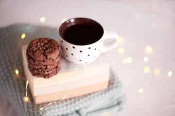 Tasty cookies with mug og coffee closeup in room over lights at back. Good morning. Breakfast. Winter season.  New Year.