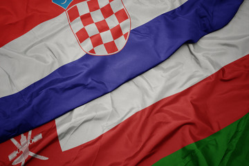 waving colorful flag of oman and national flag of croatia.