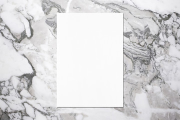 Empty white vertical rectangle poster mockup with soft shadow on grey marble background. Flat lay,...