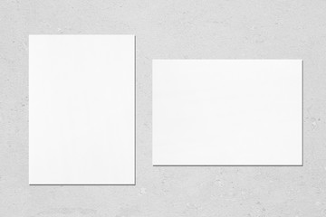 Two empty white vertical and horizontal rectangle poster mockups with soft shadows on neutral light...