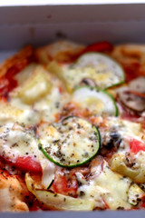 Small vegetarian pizza in a box. Take away food. Selective focus.