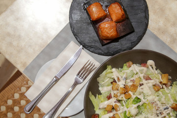 A Caesar salad with grilled tuna pieces served on the restaurant table, tasty and healthy summer meal