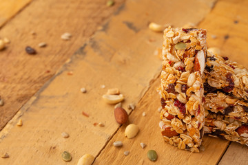 granola bars and nuts on a wooden background with space for design, horizontal photo, diet, proper nutrition