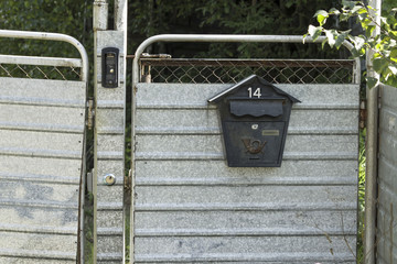 letter box on a metal fence in the daytime in summer