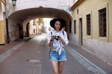 Naklejka premium The girl in the black hat shooting in an old european town.