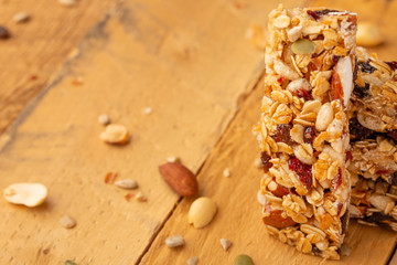 granola bars and nuts on a wooden background with space for design, horizontal photo, diet, proper nutrition