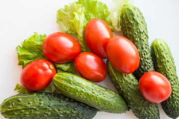 vegan ripe cucumbers and tomatoes with lettuce on a white background