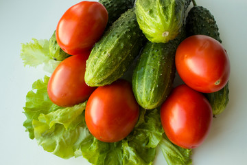 vegan ripe cucumbers and tomatoes with lettuce on a white background