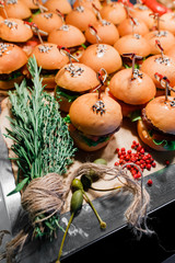 Obraz na płótnie Canvas homemade burgers lie on a table decorated with rosemary, red pepper and capers
