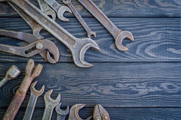 Rusty Old Tools on black vintage wood background.