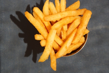 Top view of french fries in a small bucket.