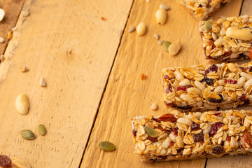 granola bars and nuts on a wooden background with space for design, horizontal photo, diet, proper nutrition