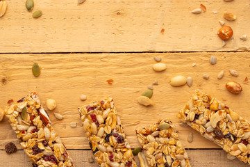 granola bars and nuts on a wooden background with space for design, horizontal photo, diet, proper nutrition