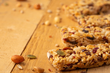 granola bars and nuts on a wooden background with space for design, horizontal photo, diet, proper nutrition