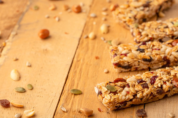 granola bars and nuts on a wooden background with space for design, horizontal photo, diet, proper nutrition