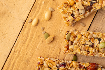 granola bars and nuts on a wooden background with space for design, horizontal photo, diet, proper nutrition