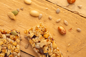 granola bars and nuts on a wooden background