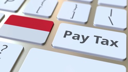 PAY TAX text and flag of Indonesia on the buttons on the computer keyboard. Taxation related conceptual 3D animation