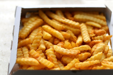 Curly fries in a box. Take away food. Selective focus.