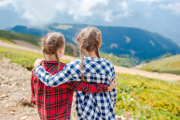 Beautiful happy little girls in mountains in the background of fog © travnikovstudio