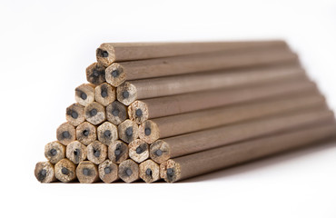 pyramid of wooden unsharpened pencils on a white background