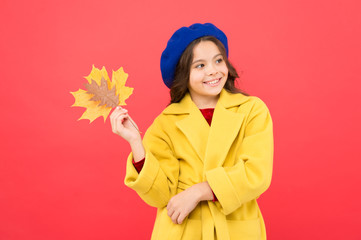 fall season. fallen leaves bunch. happy little girl with maple leaf. parisian girl child in french beret and yellow coat. autumn kid fashion. school time. childhood happiness. Carefree and happy