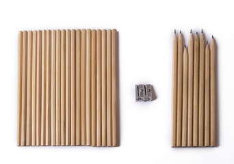 new and used wooden pencils lie nearby and a sharpener. on a white background